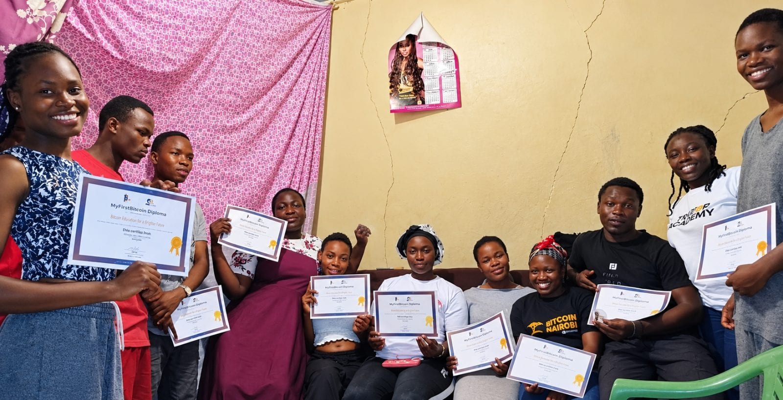 Sats4safari students celebrating their MyFirstBitcoin Diploma graduation, smiling and holding certificates after completing a Bitcoin education program.